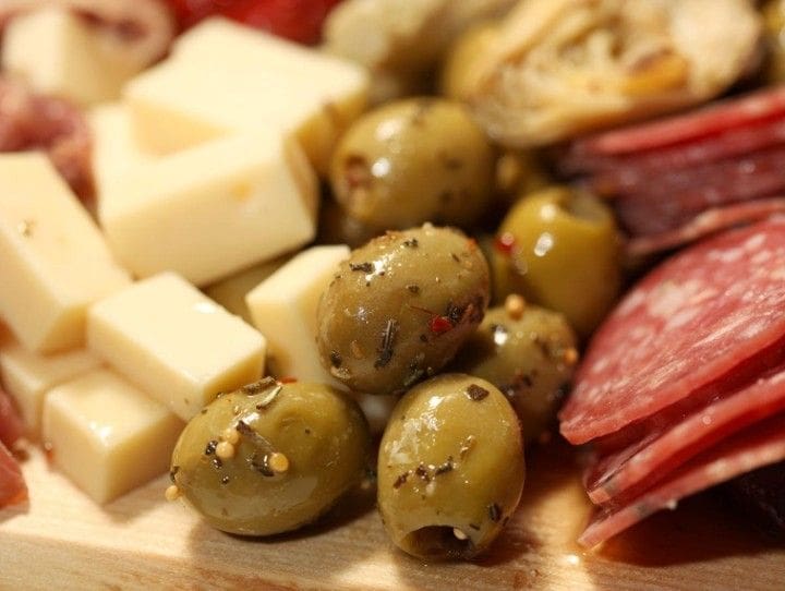 A close up of olives and cheese on a plate