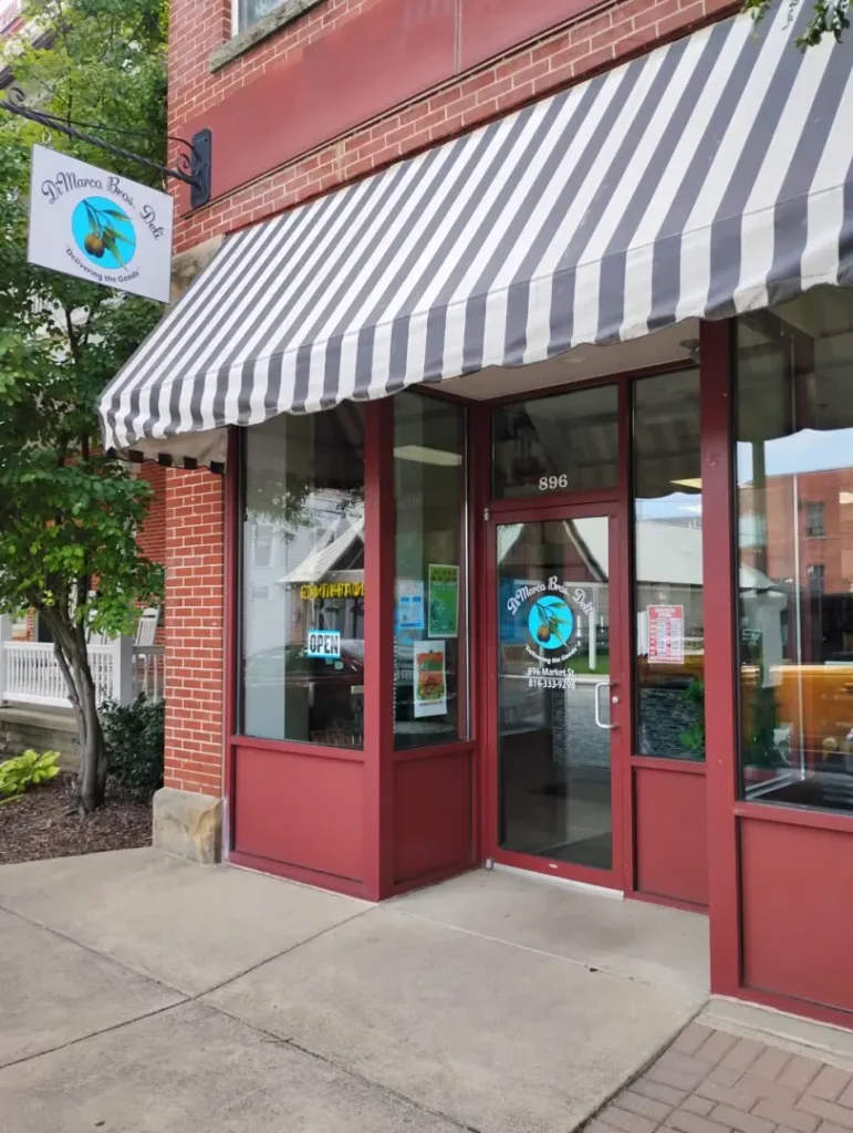 Storefront with striped awning and sign.