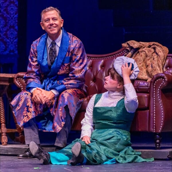 Man and child in period costumes on stage.