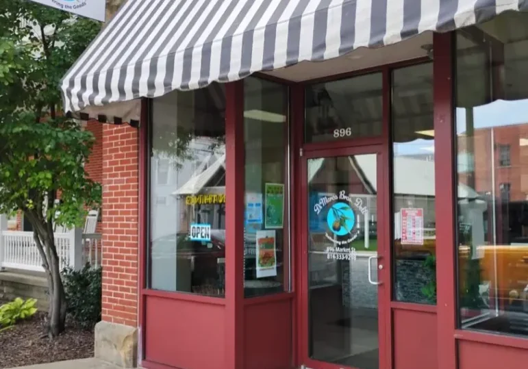 Storefront with striped awning and sign.