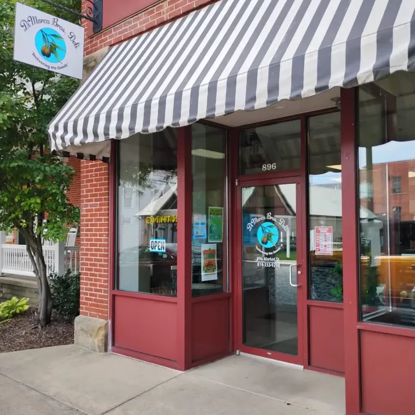Storefront with striped awning and sign.