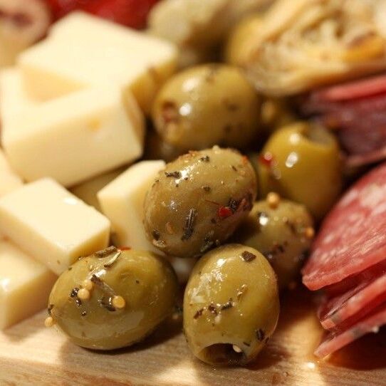 A close up of olives and cheese on a plate
