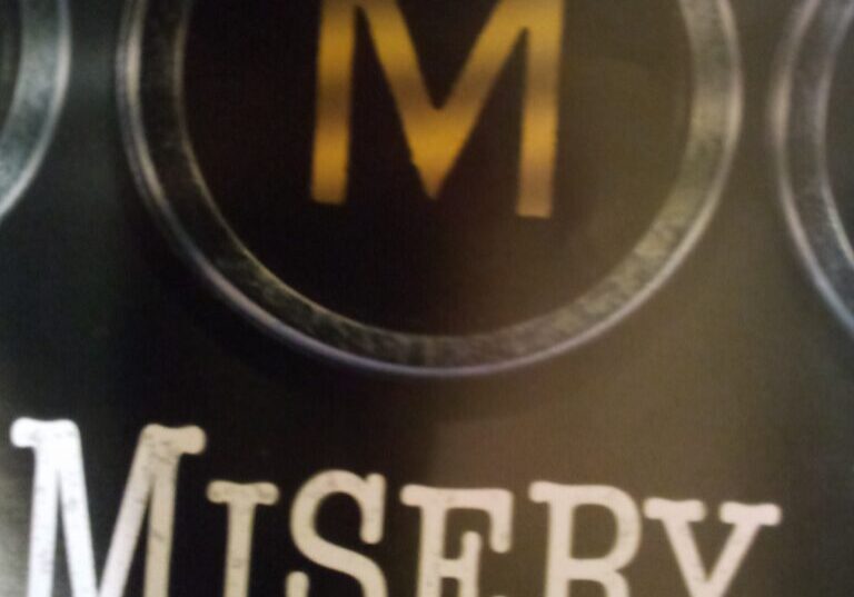A close up of the word misery on a sign