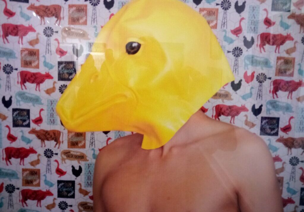 A man with a duck mask on his head.