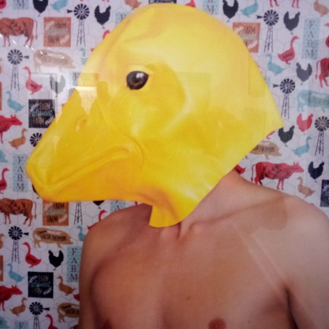 A man with a duck mask on his head.